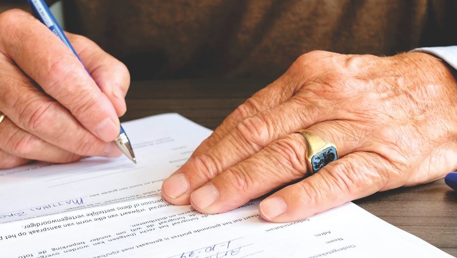 man signing paperwork forms